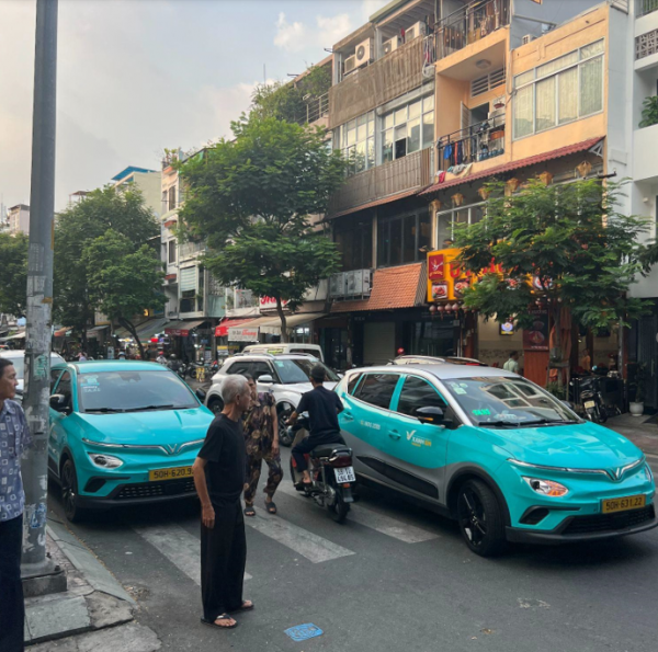 VinFast taxis picking up and dropping off people on a crowded street in District 1 of Ho Chi Minh City2.